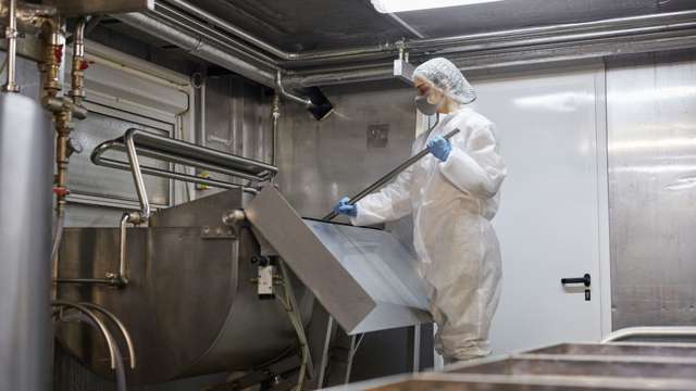 Woman cleaning vats at dairy