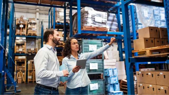 Man and woman inspecting warehouse